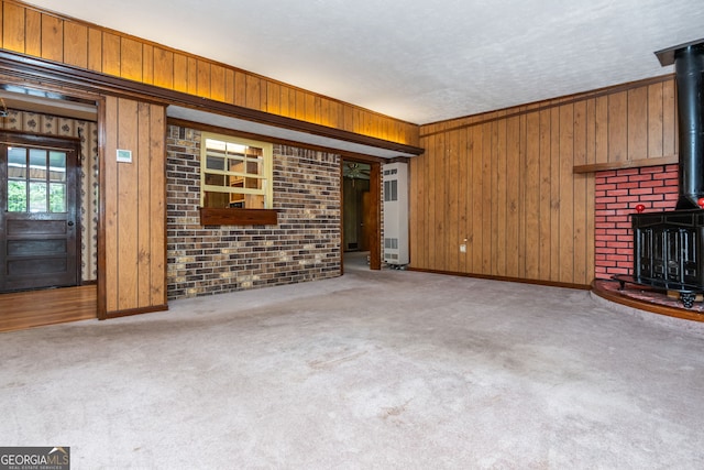 3549 Dogwood Dr, Powder Springs, GA 30127 - unfurnished living room featuring a wood stove, wood walls, carpet flooring, and baseboards
