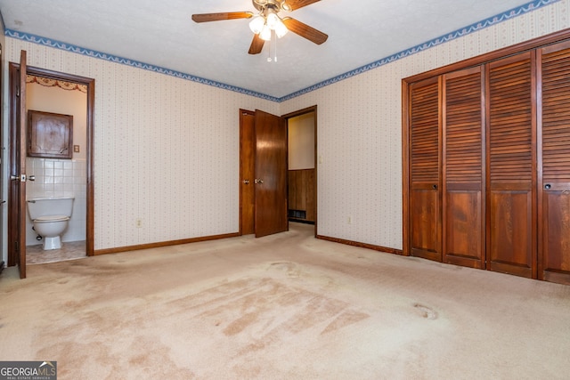 3549 Dogwood Dr, Powder Springs, GA 30127 - unfurnished bedroom with a closet, carpet, connected bathroom, baseboards, and wallpapered walls