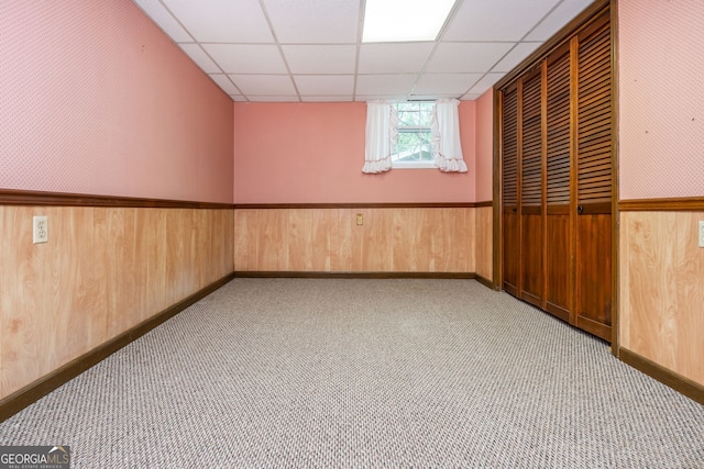 3549 Dogwood Dr, Powder Springs, GA 30127 - carpeted empty room with a paneled ceiling, wooden walls, a wainscoted wall, and baseboards