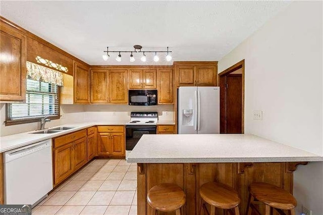 2270 Dinsmore Rd, Alpharetta, GA 30004 - kitchen with white appliances, a sink, light countertops, light tile patterned floors, and brown cabinetry