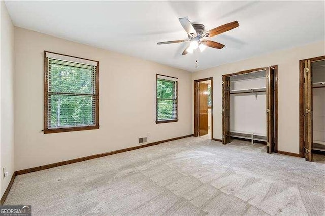 2270 Dinsmore Rd, Alpharetta, GA 30004 - unfurnished bedroom with multiple closets, light colored carpet, baseboards, and ceiling fan
