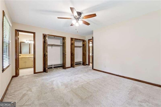 2270 Dinsmore Rd, Alpharetta, GA 30004 - unfurnished bedroom featuring light colored carpet, two closets, baseboards, connected bathroom, and a ceiling fan