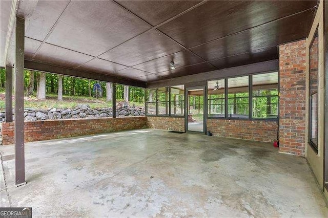 2270 Dinsmore Rd, Alpharetta, GA 30004 - unfurnished sunroom with brick wall, unfinished concrete floors, and healthy amount of natural light