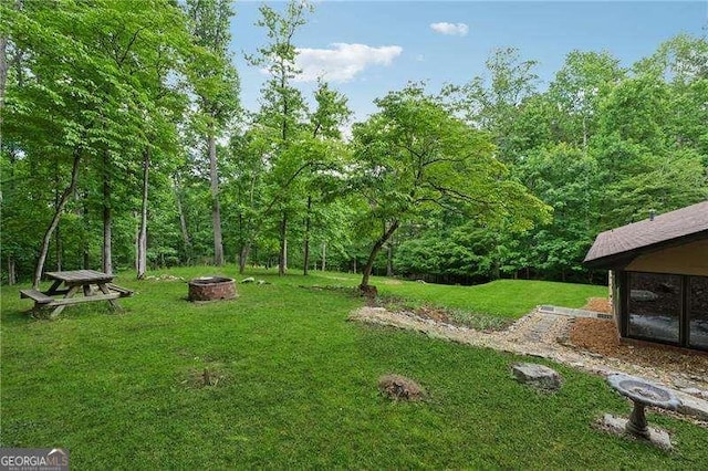 2270 Dinsmore Rd, Alpharetta, GA 30004 - view of grassy yard featuring a fire pit and a view of trees