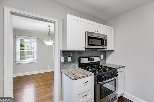 1318 Beecher St SW, Atlanta, GA 30310 - kitchen featuring appliances with stainless steel finishes, light stone counters, dark wood-type flooring, backsplash, and white cabinets