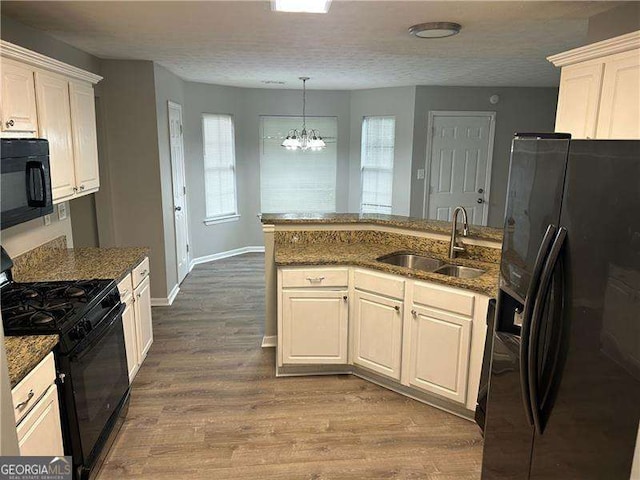 5755 Belmont Ridge Cir, Lithonia, GA 30038 - kitchen with black appliances, a chandelier, dark stone countertops, dark wood-style floors, and white cabinets