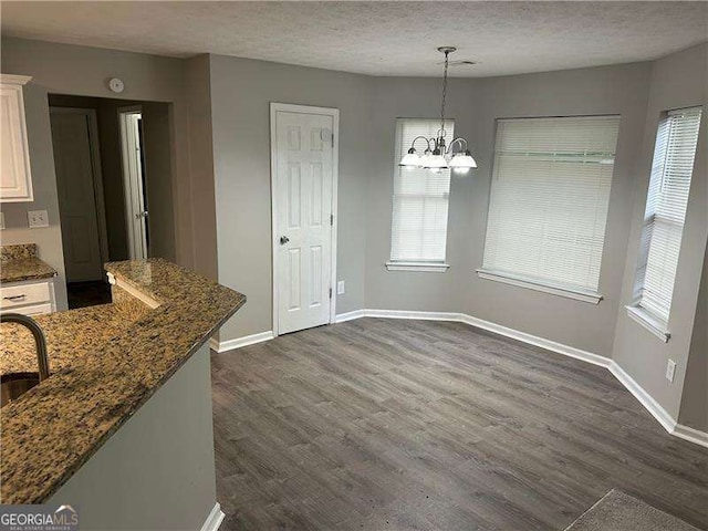 5755 Belmont Ridge Cir, Lithonia, GA 30038 - unfurnished dining area with dark wood-style floors, a chandelier, plenty of natural light, and a textured ceiling