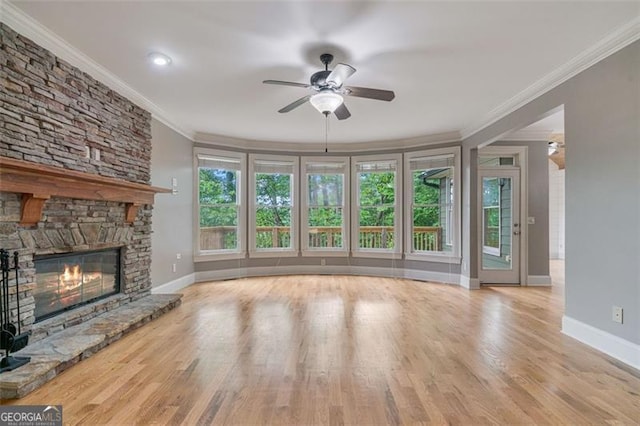 109 Sitting Bull Ct, Waleska, GA 30183 - unfurnished living room with crown molding, a ceiling fan, a stone fireplace, baseboards, and wood finished floors
