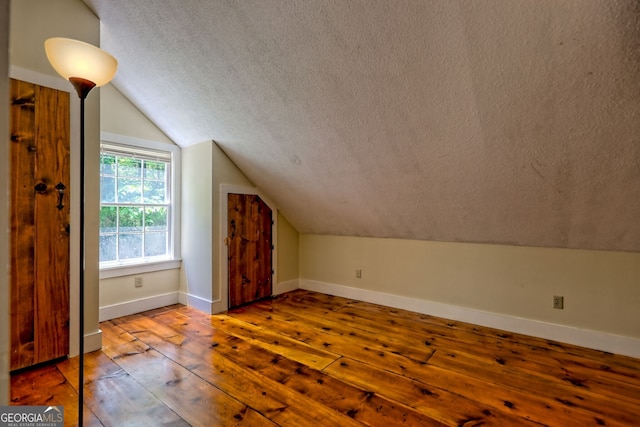 218 Jefferson Pl, Toccoa, GA 30577 - additional living space featuring a textured ceiling, hardwood / wood-style floors, vaulted ceiling, and baseboards