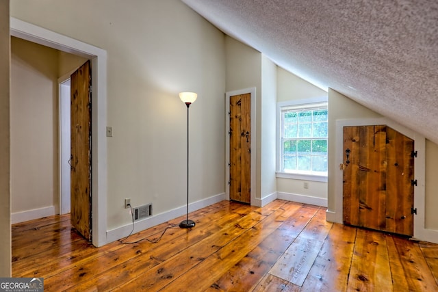 218 Jefferson Pl, Toccoa, GA 30577 - bonus room with lofted ceiling, a textured ceiling, hardwood / wood-style flooring, and baseboards