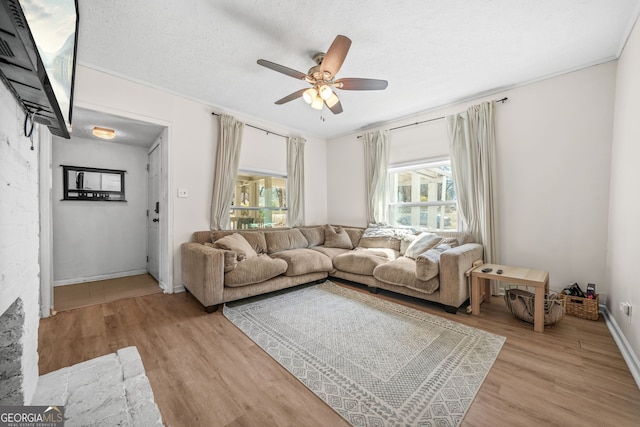 2826 Ben Hill Rd, East Point, GA 30344 - living room featuring light wood-style flooring, a ceiling fan, baseboards, a textured ceiling, and ornamental molding