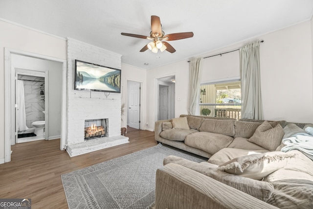 2826 Ben Hill Rd, East Point, GA 30344 - living room featuring a ceiling fan, a multi sided fireplace, wood finished floors, crown molding, and baseboards
