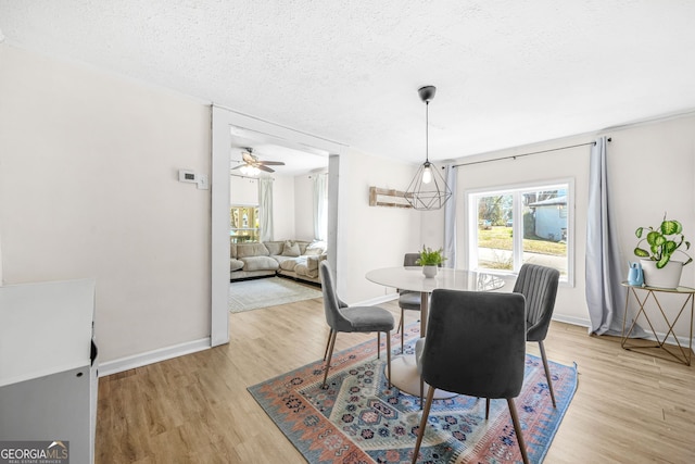 2826 Ben Hill Rd, East Point, GA 30344 - dining space with light wood-style flooring, a textured ceiling, baseboards, and a ceiling fan
