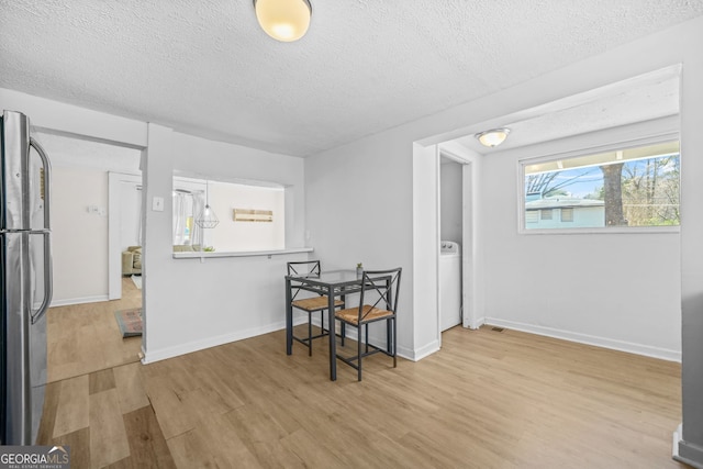 2826 Ben Hill Rd, East Point, GA 30344 - dining area with wood finished floors, a textured ceiling, baseboards, and washer / dryer