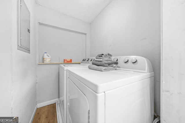 2826 Ben Hill Rd, East Point, GA 30344 - laundry area featuring washer and clothes dryer, electric panel, light wood-style flooring, a textured ceiling, and baseboards