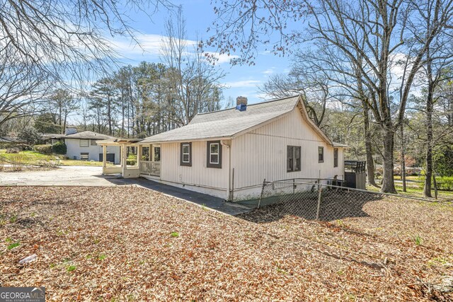 2826 Ben Hill Rd, East Point, GA 30344 - view of home's exterior featuring a chimney, roof with shingles, and a patio area