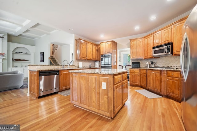 1898 Alcovy Shoals Blf SE, Lawrenceville, GA 30045 - kitchen featuring stainless steel appliances, light wood finished floors, light stone counters, a kitchen island, and recessed lighting