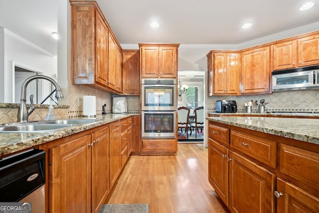 1898 Alcovy Shoals Blf SE, Lawrenceville, GA 30045 - kitchen featuring stainless steel appliances, a sink, backsplash, ornamental molding, and light wood-style flooring