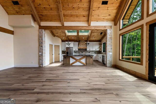 458 Palisade Dr Unit 2142, Ellijay, GA 30540 - kitchen with stainless steel appliances, wood ceiling with exposed beams, white cabinetry, wall chimney exhaust hood, and light wood-style floors