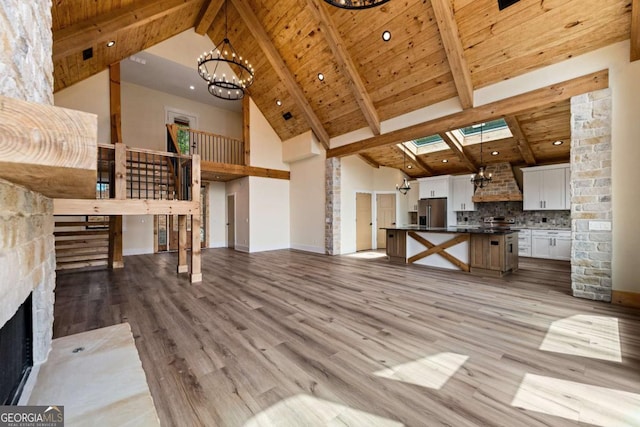 458 Palisade Dr Unit 2142, Ellijay, GA 30540 - unfurnished living room featuring a chandelier, high vaulted ceiling, a skylight, wooden ceiling with exposed beams, and light wood-type flooring