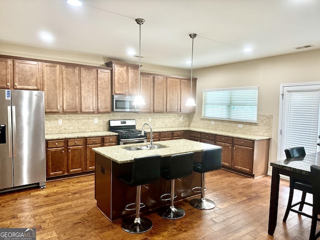 9108 Alden Dr, Locust Grove, GA 30248 - kitchen featuring stainless steel appliances, dark wood finished floors, an island with sink, tasteful backsplash, and a breakfast bar