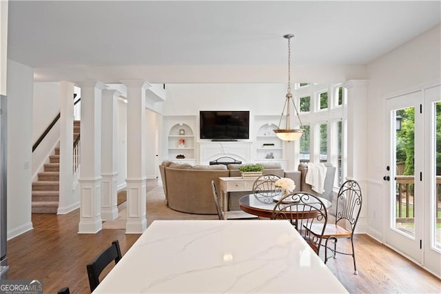 4108 Wyndam Hill Dr, Suwanee, GA 30024 - dining room with wood finished floors, stairway, a fireplace, and built in shelves