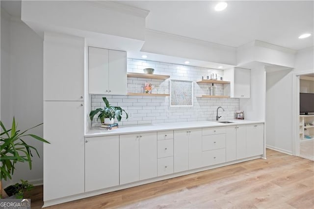 4108 Wyndam Hill Dr, Suwanee, GA 30024 - kitchen featuring open shelves, light countertops, backsplash, white cabinets, and light wood-style flooring