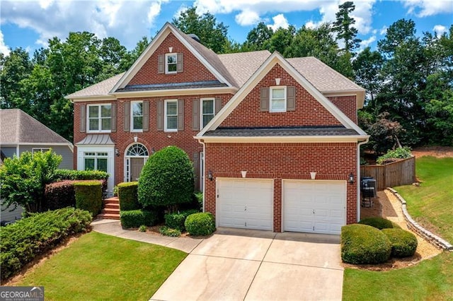 4108 Wyndam Hill Dr, Suwanee, GA 30024 - colonial house with an attached garage, concrete driveway, brick siding, and a front lawn