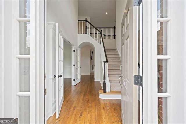 4108 Wyndam Hill Dr, Suwanee, GA 30024 - entrance foyer featuring french doors, stairway, wood finished floors, arched walkways, and a high ceiling