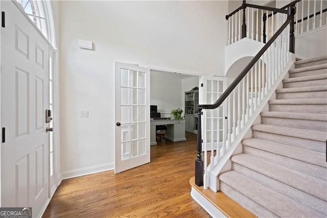4108 Wyndam Hill Dr, Suwanee, GA 30024 - foyer entrance with a towering ceiling, stairs, wood finished floors, and french doors