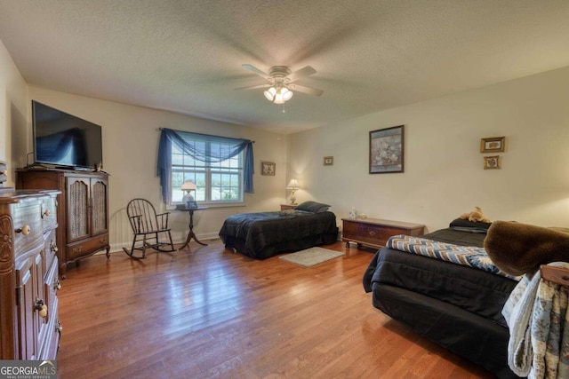 2008 Hidden Valley Rd, Hiawassee, GA 30546 - bedroom with wood finished floors, a textured ceiling, a ceiling fan, and baseboards