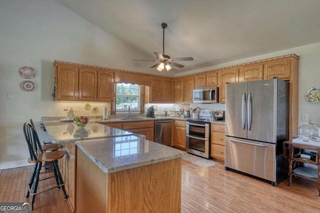 2008 Hidden Valley Rd, Hiawassee, GA 30546 - kitchen with stainless steel appliances, light wood finished floors, a peninsula, a sink, and a ceiling fan