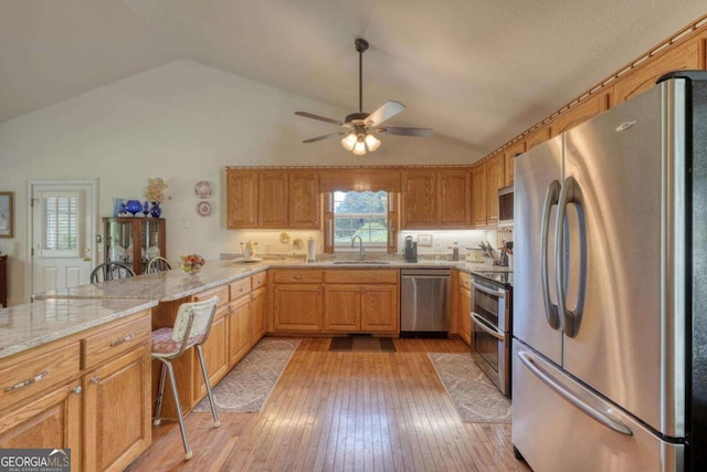 2008 Hidden Valley Rd, Hiawassee, GA 30546 - kitchen featuring stainless steel appliances, vaulted ceiling, a sink, ceiling fan, and light wood finished floors