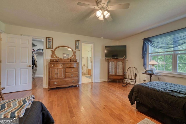 2008 Hidden Valley Rd, Hiawassee, GA 30546 - bedroom with light wood-type flooring, a spacious closet, ensuite bathroom, a textured ceiling, and baseboards