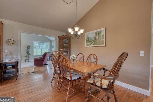 2008 Hidden Valley Rd, Hiawassee, GA 30546 - dining room with vaulted ceiling, light wood finished floors, baseboards, and a chandelier