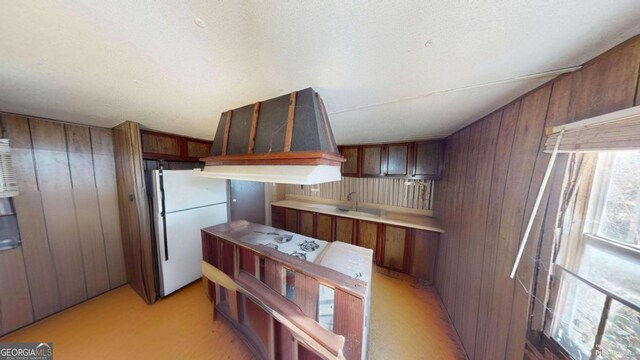 85 Lang Cir, Covington, GA 30014 - kitchen with freestanding refrigerator, wooden walls, and light countertops