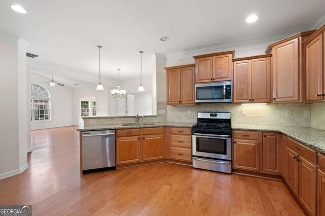 2061 Grove Field Ln, Marietta, GA 30064 - kitchen with stainless steel appliances, a sink, ornamental molding, light stone countertops, and pendant lighting