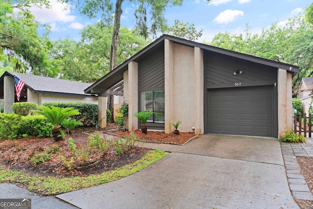 107 Linkside Dr, Saint Simons, GA 31522 - view of front facade featuring driveway, stucco siding, and an attached garage