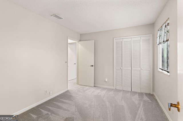107 Linkside Dr, Saint Simons, GA 31522 - unfurnished bedroom featuring carpet floors, baseboards, a closet, and a textured ceiling