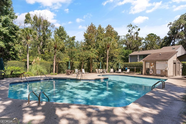 107 Linkside Dr, Saint Simons, GA 31522 - community pool featuring a patio area and view of wooded area