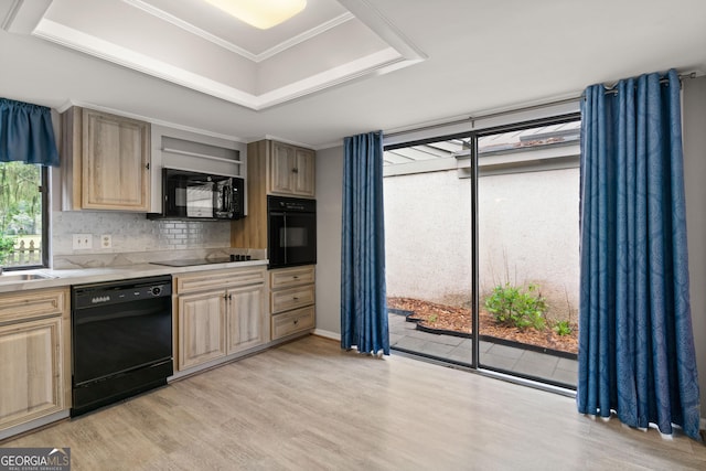 107 Linkside Dr, Saint Simons, GA 31522 - kitchen featuring black appliances, light wood-type flooring, light countertops, tasteful backsplash, and a tray ceiling