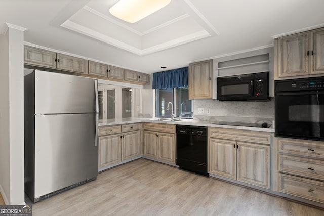 107 Linkside Dr, Saint Simons, GA 31522 - kitchen with black appliances, a sink, a tray ceiling, light countertops, and ornamental molding