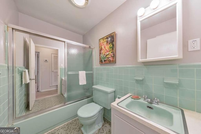 1111 Clairemont Ave Unit N3, Decatur, GA 30030 - full bath featuring vanity, toilet, tile walls, combined bath / shower with glass door, and a wainscoted wall