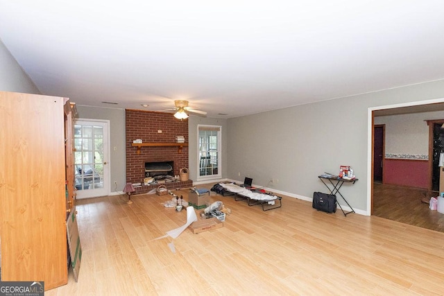 701 Log Landing Rd, Springfield, GA 31329 - unfurnished living room with a fireplace, a ceiling fan, wood finished floors, and baseboards