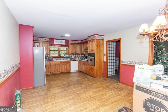 701 Log Landing Rd, Springfield, GA 31329 - kitchen with appliances with stainless steel finishes, a chandelier, light wood finished floors, extractor fan, and light countertops