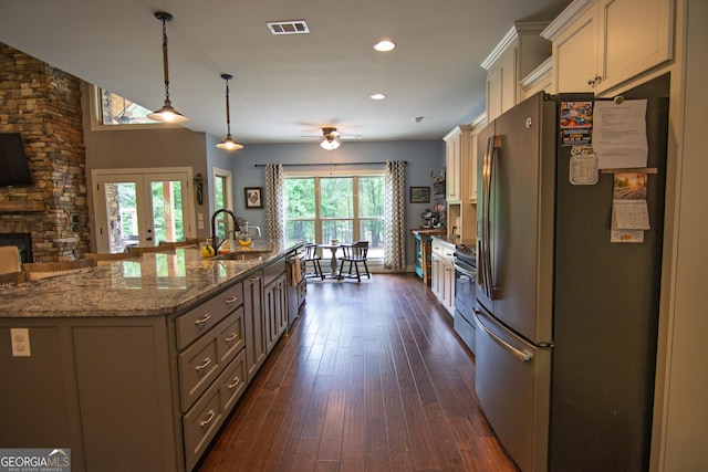 299 Savior Ln, Hamilton, GA 31811 - kitchen featuring appliances with stainless steel finishes, a sink, a spacious island, dark wood-style flooring, and light stone countertops