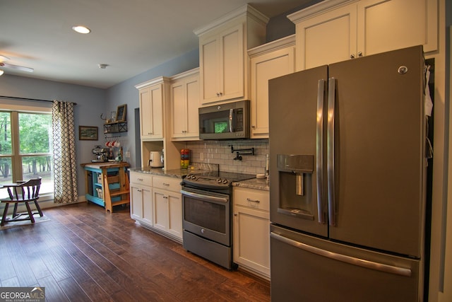 299 Savior Ln, Hamilton, GA 31811 - kitchen with appliances with stainless steel finishes, decorative backsplash, stone counters, cream cabinets, and dark wood-style floors