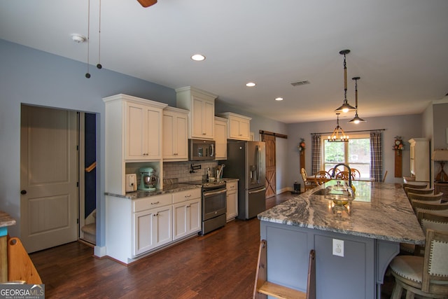 299 Savior Ln, Hamilton, GA 31811 - kitchen featuring stainless steel appliances, a kitchen bar, decorative backsplash, dark wood finished floors, and recessed lighting