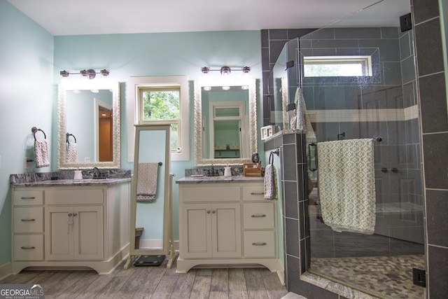 299 Savior Ln, Hamilton, GA 31811 - bathroom with wood finished floors, a shower stall, and two vanities