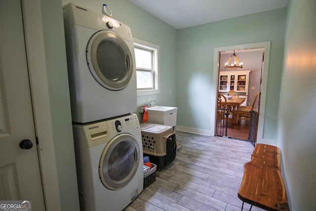 299 Savior Ln, Hamilton, GA 31811 - laundry area with estacked washer and dryer, a chandelier, light wood-style floors, and baseboards